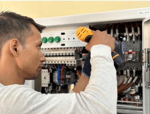 Electricista verificado de Maestro trabajando en un tablero eléctrico durante una revisión en Bogotá