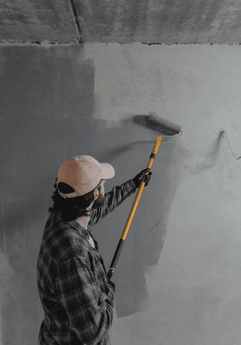 Técnico verificado de Maestro pintando una pared con rodillo durante un mantenimiento locativo en Bogotá